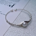 Detailed view of silver wire-wrapped freshwater pearl bracelet on a white textured background - Silver Single Pearl Wrap / Silver