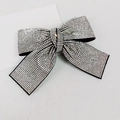 Dettaglio di un fermaglio per capelli a fiocco nero con strass bianchi brillanti su sfondo grigio - Coda di Rondine Quadrata Strass Bianco