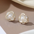 Macro detail of white enamel camellia stud earrings with gold edges and a center pearl - Pearl Camellia Stud Earrings