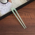 U-shaped hair pin in light green jelly acetate finish on a dark wooden surface - Jelly White