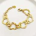 Gold-plated stainless steel chain bracelet with interlocking heart links on a white plate - Hammered Heart Links