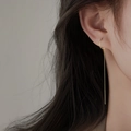 Minimalistische lange Quastenohrringe für Damen in glänzendem Gold am Modell - C-Form Lang / Gold