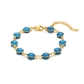 Dettaglio di un bracciale placcato oro 18k con ciondoli rotondi glitterati blu su sfondo bianco - Blu