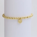 Detailed view of golden beaded bracelet with M-letter round charm on white stand - Letter M (DB240603-M)