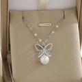Détail du collier pendentif papillon argenté avec cristaux et perle dans un écrin cadeau - Perle Papillon