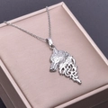Close-up of silver stainless steel wolf head pendant on a brushed metal jewelry box - Necklace / Steel
