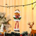 Dettaglio dell'orso di Natale in peluche appeso a un ramo con decorazioni festive - Orso