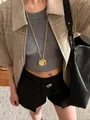 Detail of a vintage gold layered flower pendant necklace with long tassel chain on a model - Gold Mid-length Daisy Clear Gem