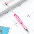 Pink DIY beadable pen with awareness ribbon pattern and marble top bead on a desk - Pink Awareness Ribbon (97)