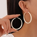 Detail showing white matte geometric hoop earrings worn and held for size reference - White Large Hoop