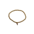 Detail of gold beaded bracelet featuring a V-shaped pendant with colorful gemstones - Letter V