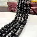 Polished natural black obsidian beads with silver sheen and cat-eye effect on white plate - Silver Obsidian 53 / 6mm / Approx 63pcs