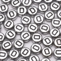Flat lay of silver 4x7mm round acrylic alphabet beads with black uppercase letter D - Letter D