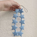 Blue silicone star-shaped bead chain keychain with gold ring held by hand - Dark Gray Blue (10 Stars)