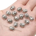 Silver alloy ladybug spacer beads for DIY jewelry making displayed on a hand - Ladybug / 9x10mm