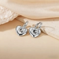 Polished silver heart-shaped hoop earrings on elegant silk background textures - Heart Pendant / Steel