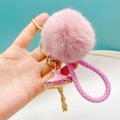 Dettaglio del portachiavi con pompon rosa, ciondolo ballerina e cinturino intrecciato - Rosa + Pompon + Cordino