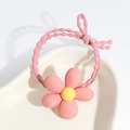 Detailed view of a pink flower hair tie with yellow center on a white display tray - Flower / Pink