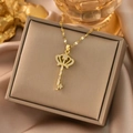 Detailed close-up of 18k gold crown key necklace with sparkling cubic zirconia inlay - Gold Key