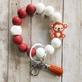 Silicone keychain bracelet with red white beads, monkey charm and orange tassel decoration - Monkey