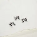 Tre ciondoli a forma di fiocco in metallo argento per gioielli fai da te su bianco - Collana a mini fiocco