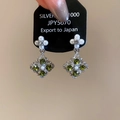 Detailed shot of silver flower earrings with green stones and pearls on a price tag - Silver Green Flower