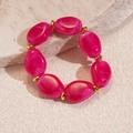Macro detail of irregular rose red resin beads with white marble texture and gold accents - Rose Red