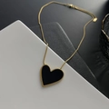 Elegant gold snake chain necklace featuring a large black heart pendant with gold trim - Gold Black Necklace