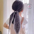 Elegant black french ribbon hair tie with white script print on a low ponytail - Black Letters
