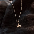 Collana elegante con ciondolo a coda di pesce dorata e zirconi su sfondo scuro testurizzato - Stile Coda di Pesce con Strass Oro (#60)