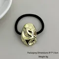 Geometric gold-toned metal hair tie with black elastic band in a modern minimalist style - Textured Bean Shape