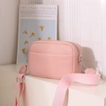 Close-up of pink pebbled leather crossbody bag with wide woven strap and silver zipper - Pink