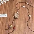 Close-up of vintage ethnic necklace with square wood pendant and star beads - Brown Square Wood Pendant