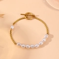 Goldenes OT-Verschluss Armband mit Barockperlen und Metallgliedern auf rosa Hintergrund - Goldenes Perlenarmband (I703)
