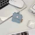 Detail of blue denim earphone case with purple snap button and white hook on desk - Light Blue