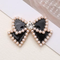 Elegante fiocco in smalto nero con perle bianche e strass scintillante al centro - Base Oro Nero