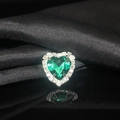 Macro detail of a heart-shaped emerald green crystal with white rhinestone halo on black silk - Dark Green