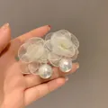 Vista dettagliata di eleganti orecchini a fiore in rete con perle bianche e placcatura oro - Stile 15 Perno in Argento