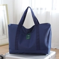 Large dark blue canvas travel tote bag with top handles shown on silver luggage - Large / Blue