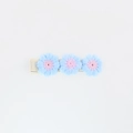Detail of three light blue hand-knitted crochet flowers with pink centers on a hair clip - Blue and Pink Crochet