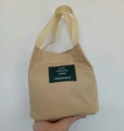 Beige minimalist canvas bucket bag with green woven label and shoulder straps - Khaki