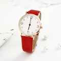 Macro view of red leather strap and rose gold watch case with numeric white dial - Red
