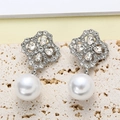 Silver four-leaf clover stud earrings with pearls and crystals on a stone background - Silver
