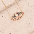 Detailaufnahme des goldenen Evil-Eye-Anhängers mit bunten Edelsteinen auf beigem Naturstein - Rosa-Schwarzer Quasten-Stil(6#)