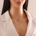 Elegant gold heart pendant necklace with deep green gemstone on a model neck - Green