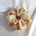 Detailed view of a gold satin silk scrunchie with soft texture on a silk background - Bright Gold