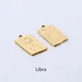Detail of two gold-plated Libra pendants featuring celestial sun and zodiac engravings - Libra