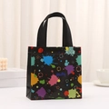 Black non-woven gift bag featuring colorful paint splatter and star patterns with handles - Colorful Stars Splatter