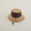 Detail of color-block kid's bucket hat featuring adjustable windproof cord and side logo - 2-5 Years Old / Khaki & Beige