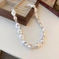Barockperlenkette mit Goldverschluss elegant auf weißem Tisch neben einem Buch platziert - Weiß - Unregelmäßig